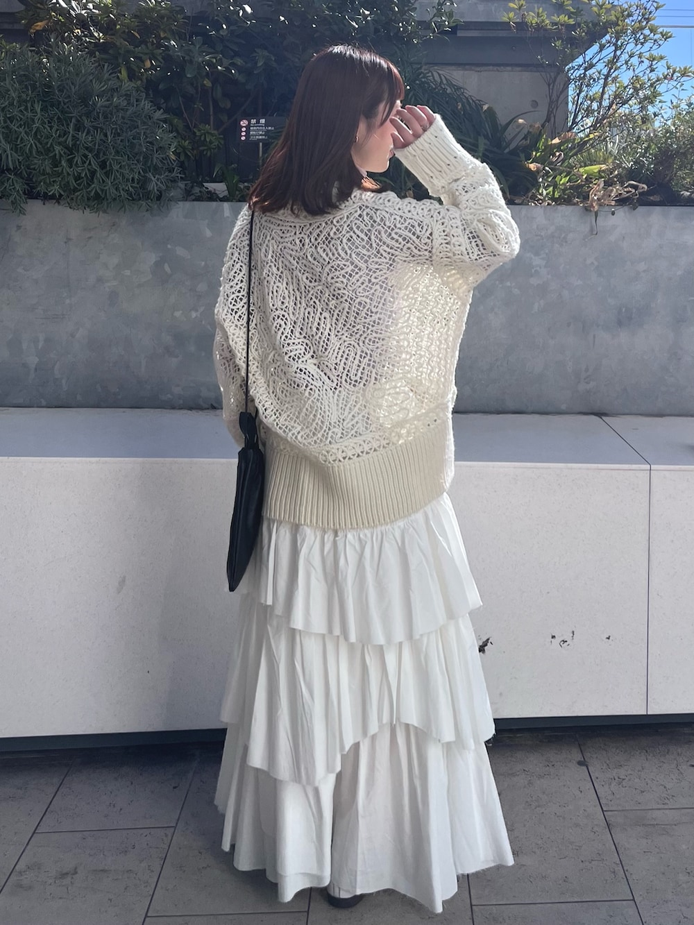 ホワイト系のニット/セーター、ホワイト系のスカート、パープル系のTシャツ/カットソーを着用したレディースの冬コーディネートの4枚目の写真