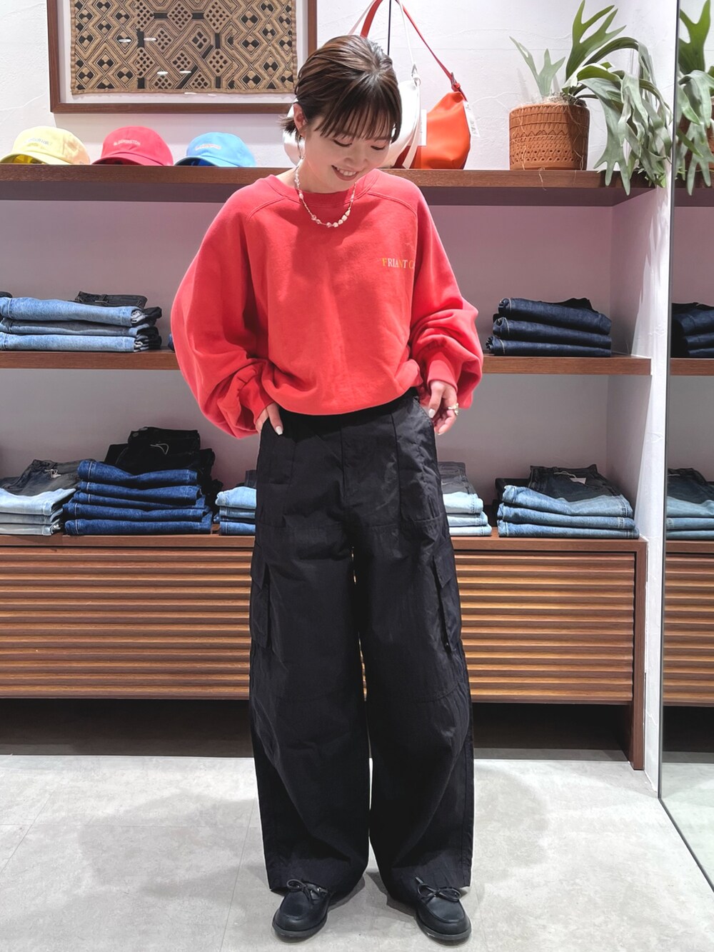 レッド系のスウェット、ブラック系のその他パンツ、ブラック系のローファーを着用したレディースの春コーディネートの2枚目の写真