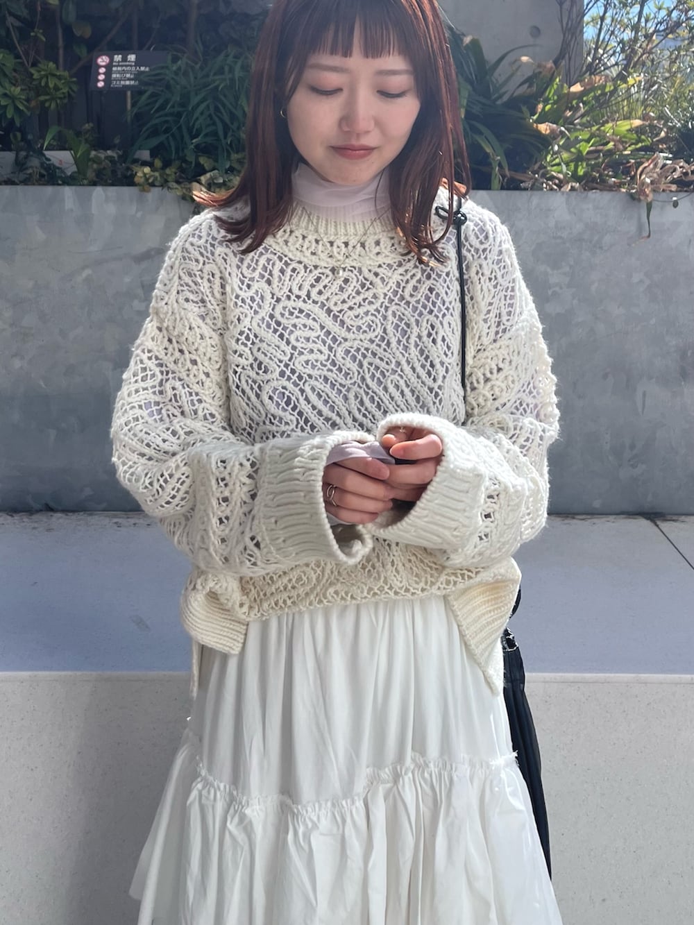 ホワイト系のニット/セーター、ホワイト系のスカート、パープル系のTシャツ/カットソーを着用したレディースの冬コーディネートの6枚目の写真