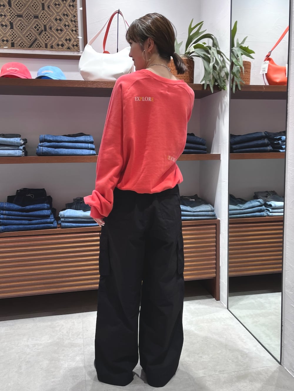 レッド系のスウェット、ブラック系のその他パンツ、ブラック系のローファーを着用したレディースの春コーディネートの4枚目の写真