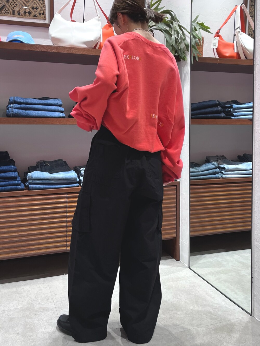 レッド系のスウェット、ブラック系のその他パンツ、ブラック系のローファーを着用したレディースの春コーディネートの5枚目の写真