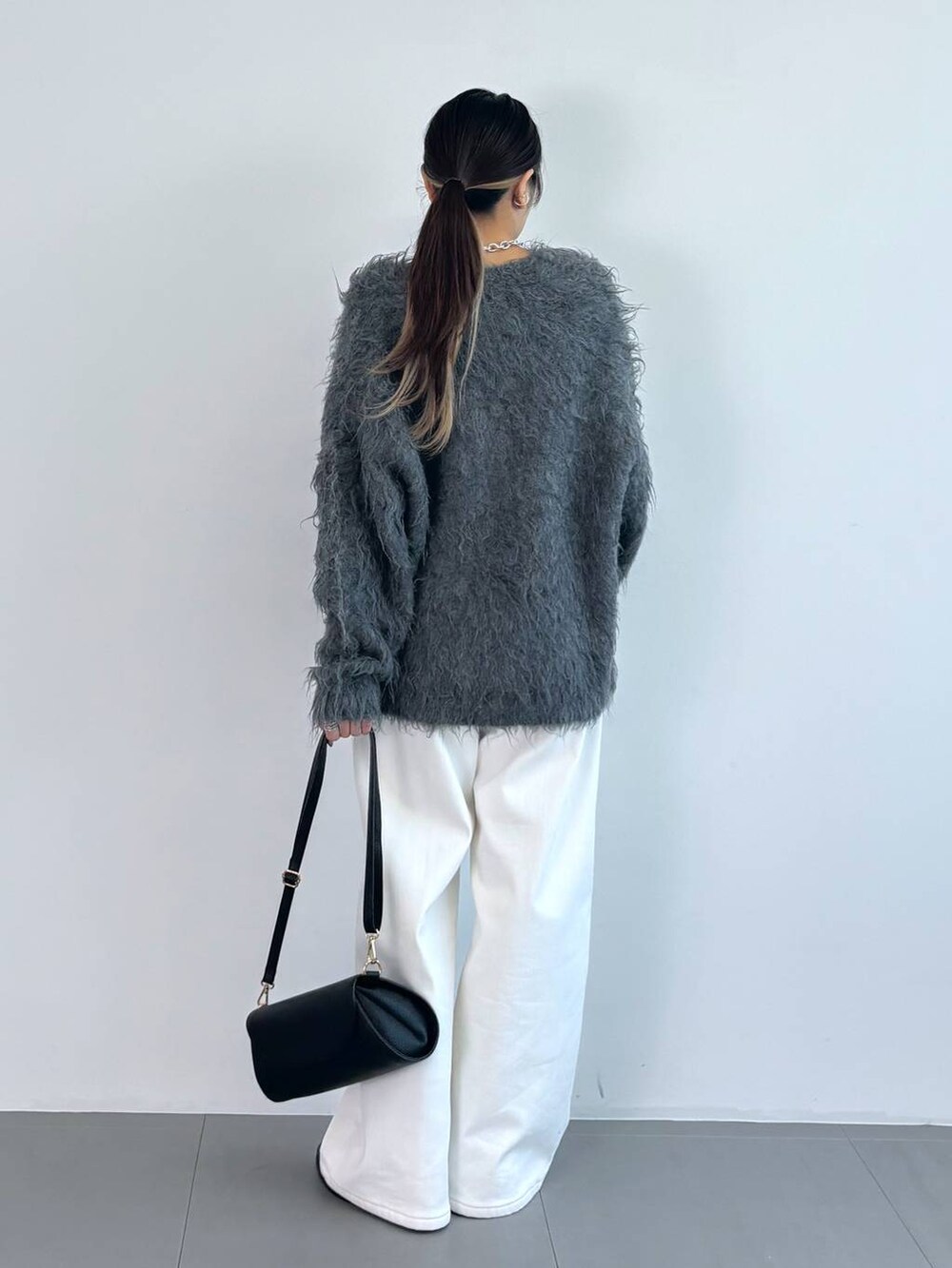 ブラック系のブーツ、ブラック系のタンクトップ、ブラック系のショルダーバッグを着用したレディースの秋コーディネートの4枚目の写真