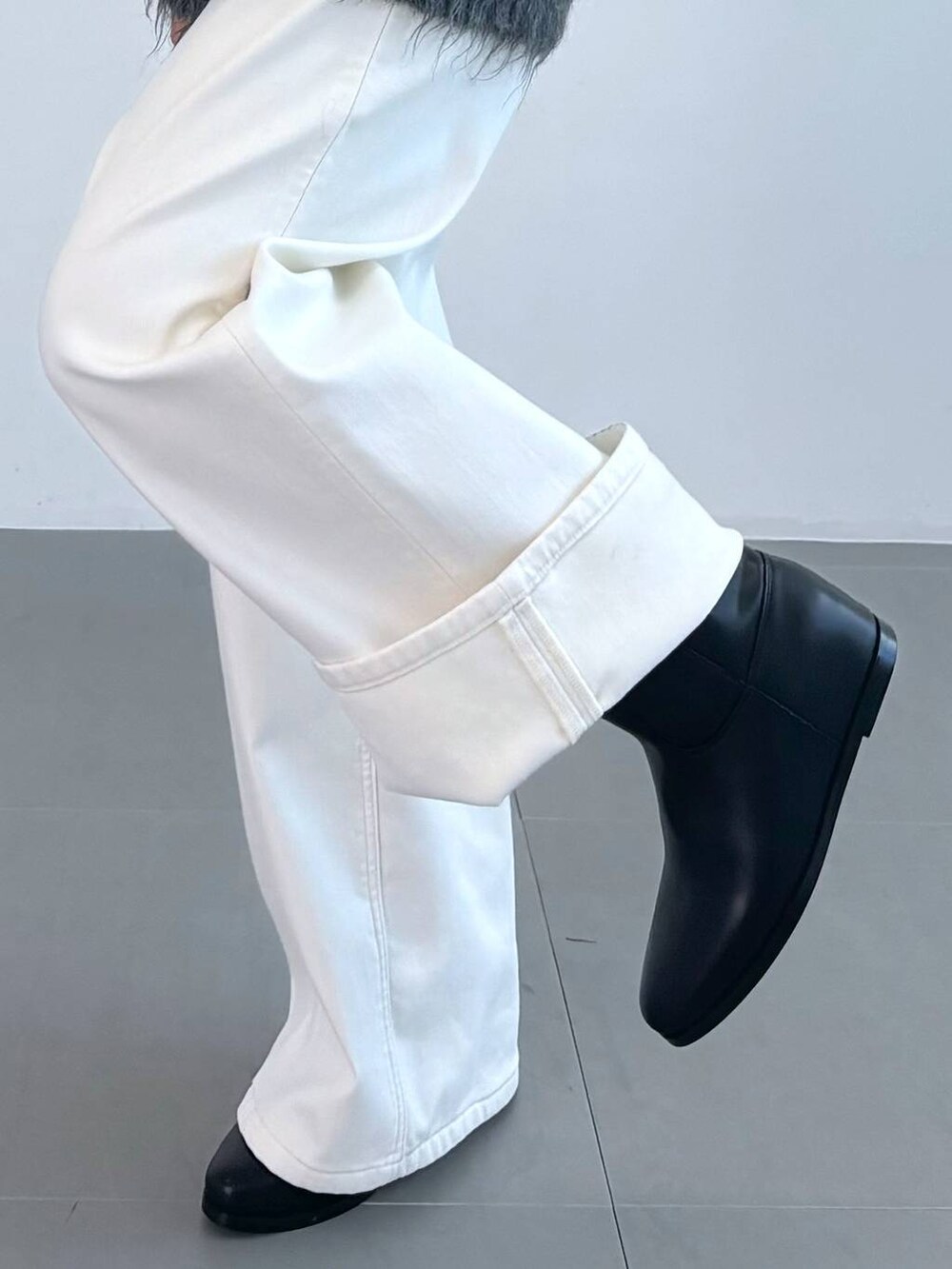 ブラック系のブーツ、ブラック系のタンクトップ、ブラック系のショルダーバッグを着用したレディースの秋コーディネートの2枚目の写真