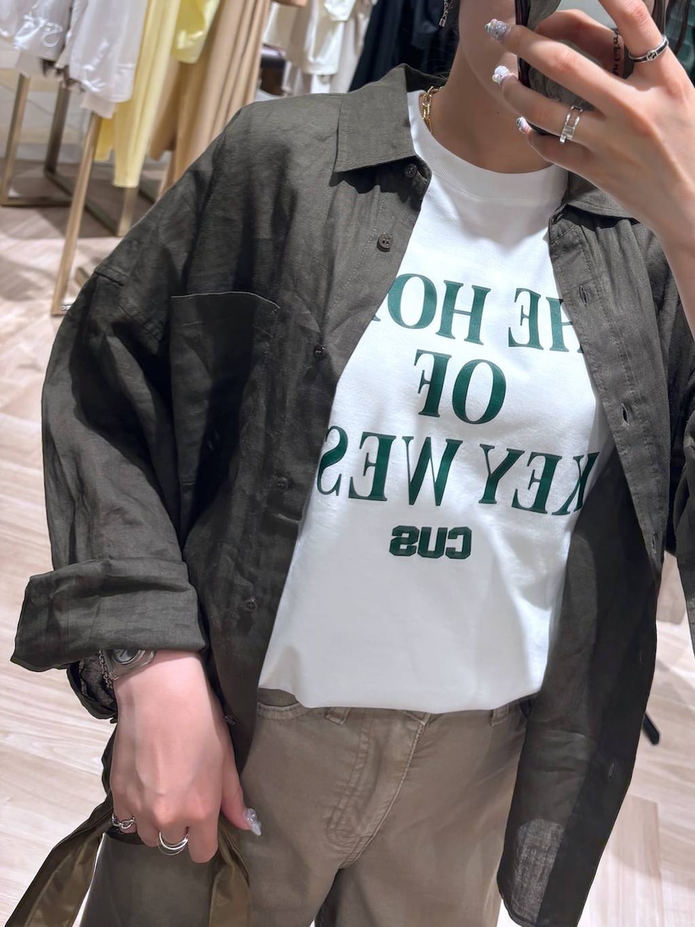 ベージュ系のデニムパンツ、グリーン系のシャツ/ブラウス、ホワイト系のTシャツ/カットソーを着用したレディースの春コーディネートの2枚目の写真