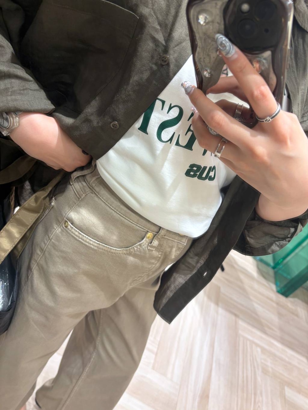 ベージュ系のデニムパンツ、グリーン系のシャツ/ブラウス、ホワイト系のTシャツ/カットソーを着用したレディースの春コーディネートの3枚目の写真