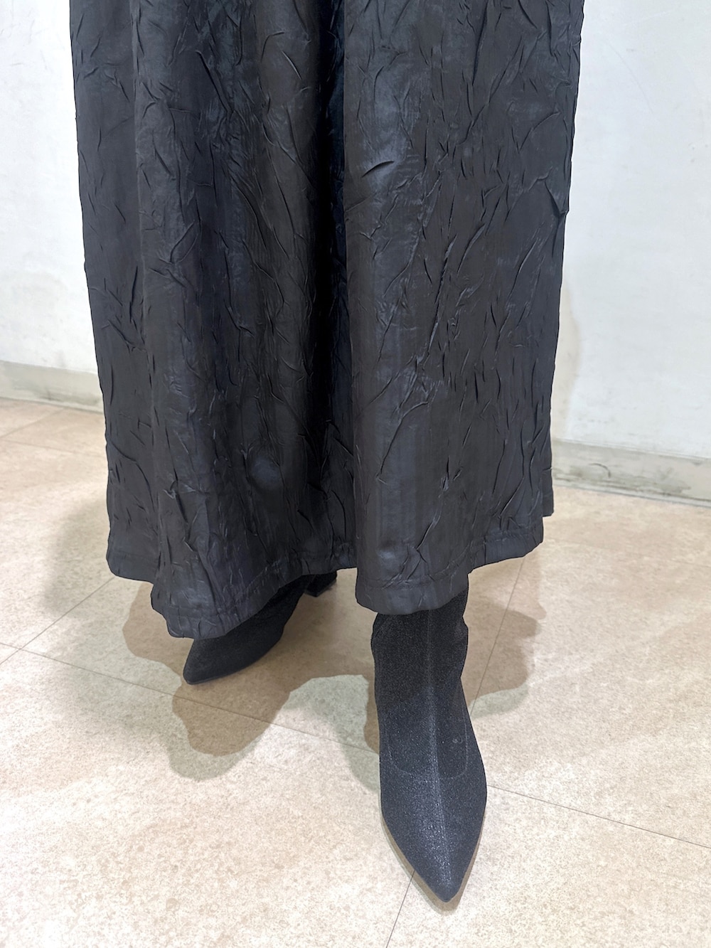 ベージュ系のトレンチコート、ブラック系のワンピース、ブラック系のTシャツ/カットソーを着用したレディースの春コーディネートの8枚目の写真