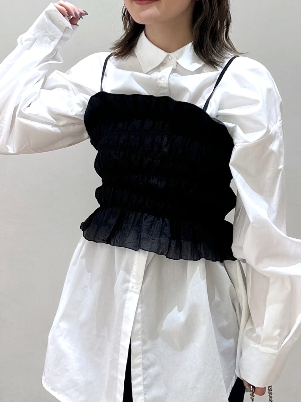 ブラック系のキャミソール、ブラック系のサンダル、ブルー系のデニムパンツを着用したレディースの春コーディネートの3枚目の写真