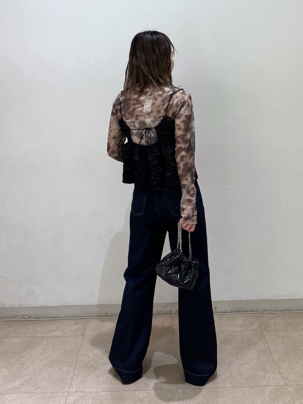 ブラック系のキャミソール、ブラック系のショルダーバッグ、ブラック系のパンプスを着用したレディースの春コーディネートの3枚目の写真