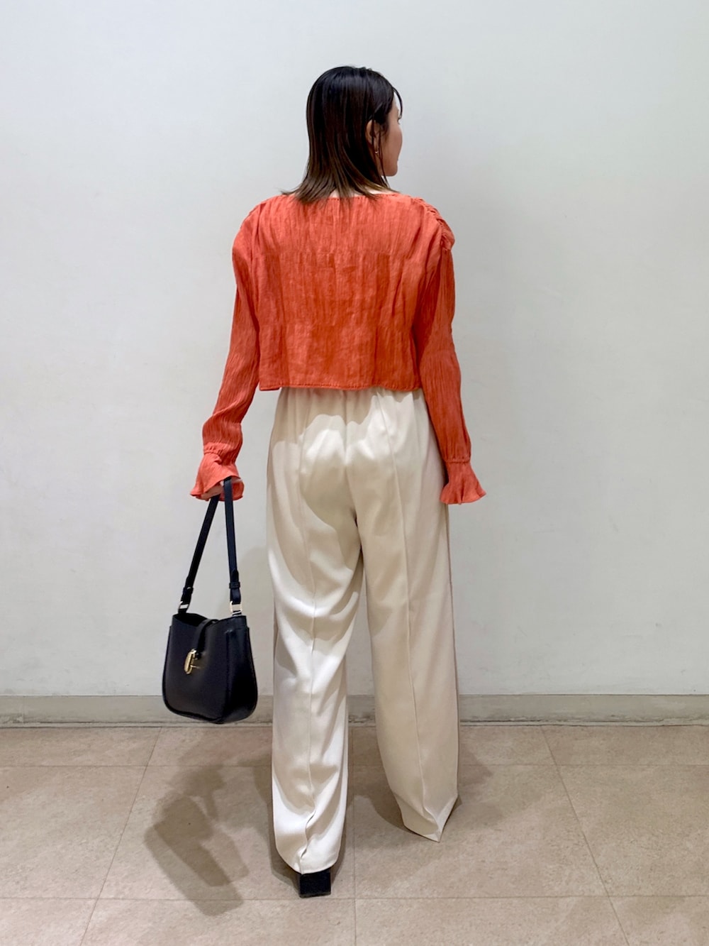 オレンジ系のカーディガン/ボレロ、ホワイト系のキャミソール、ホワイト系のその他パンツを着用したレディースの春コーディネートの3枚目の写真
