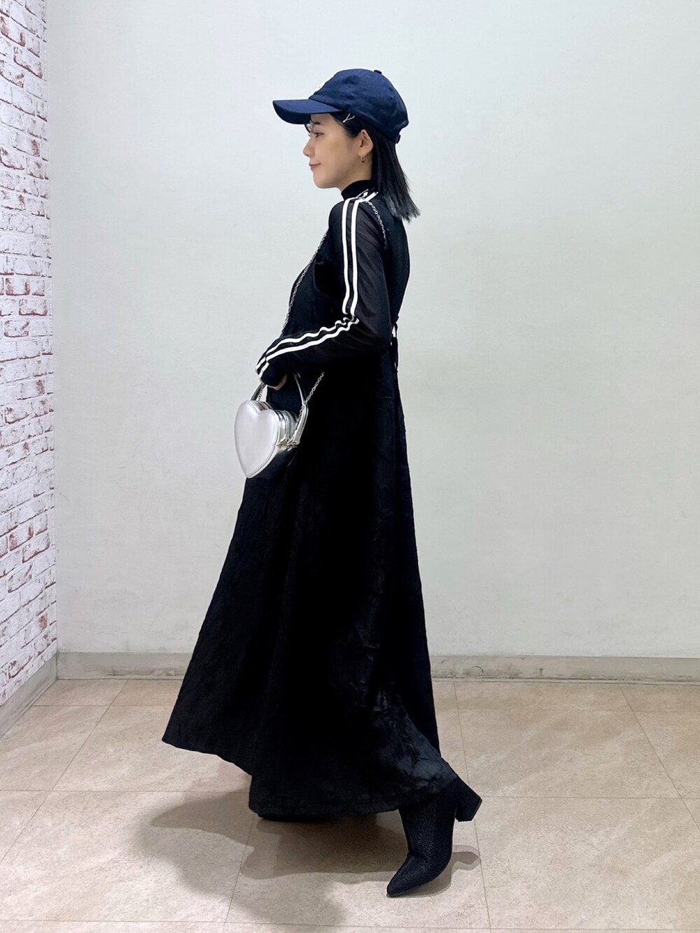 ベージュ系のトレンチコート、ブラック系のワンピース、ブラック系のTシャツ/カットソーを着用したレディースの春コーディネートの4枚目の写真