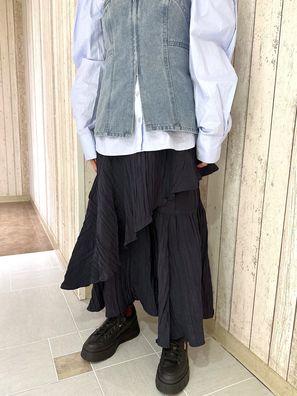 ブルー系のシャツ/ブラウス、ブルー系のベスト、ブラック系のスカートを着用したレディースの春コーディネートの5枚目の写真