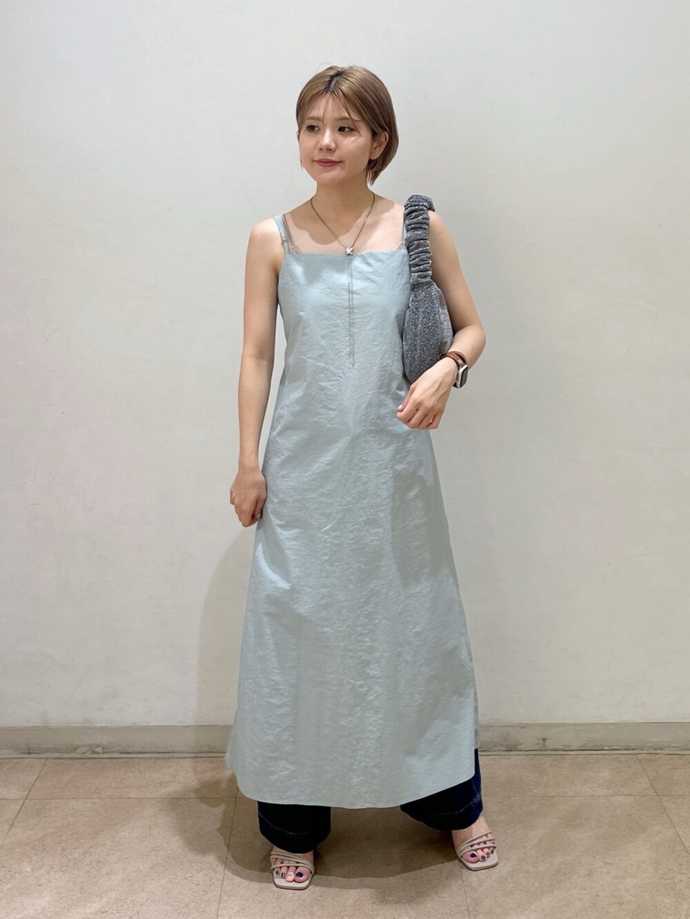 グレー系のワンピース、ブルー系のデニムパンツを着用したレディースの夏コーディネートの2枚目の写真