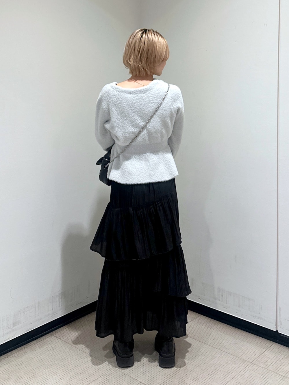 グレー系のカーディガン/ボレロ、ブラック系のスカートを着用したレディースの冬コーディネートの2枚目の写真