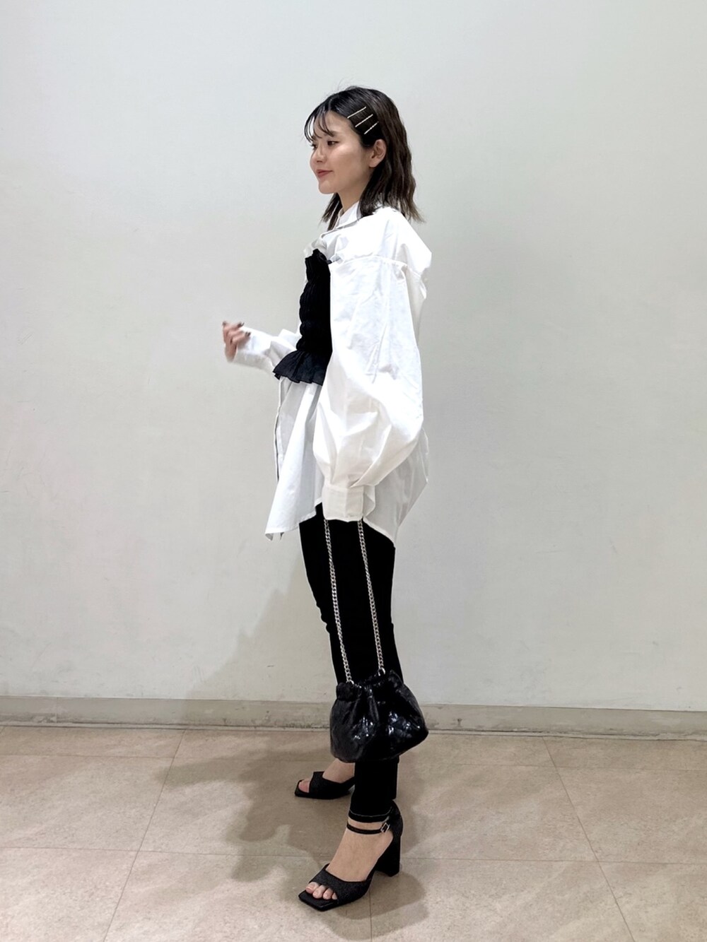 ブラック系のキャミソール、ブラック系のサンダル、ブルー系のデニムパンツを着用したレディースの春コーディネートの2枚目の写真