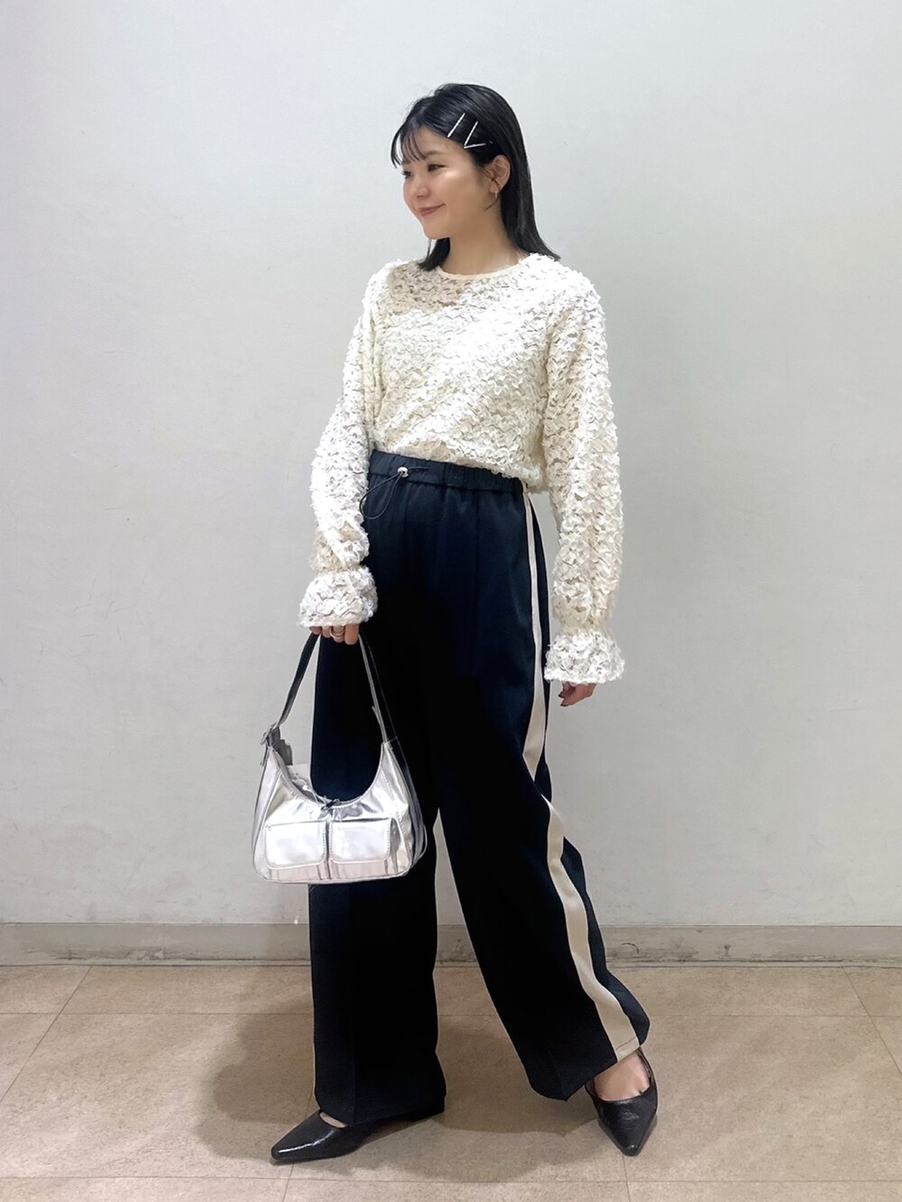 ホワイト系のシャツ/ブラウス、ブラック系のパンプス、シルバー系のショルダーバッグを着用したレディースの春コーディネートの2枚目の写真