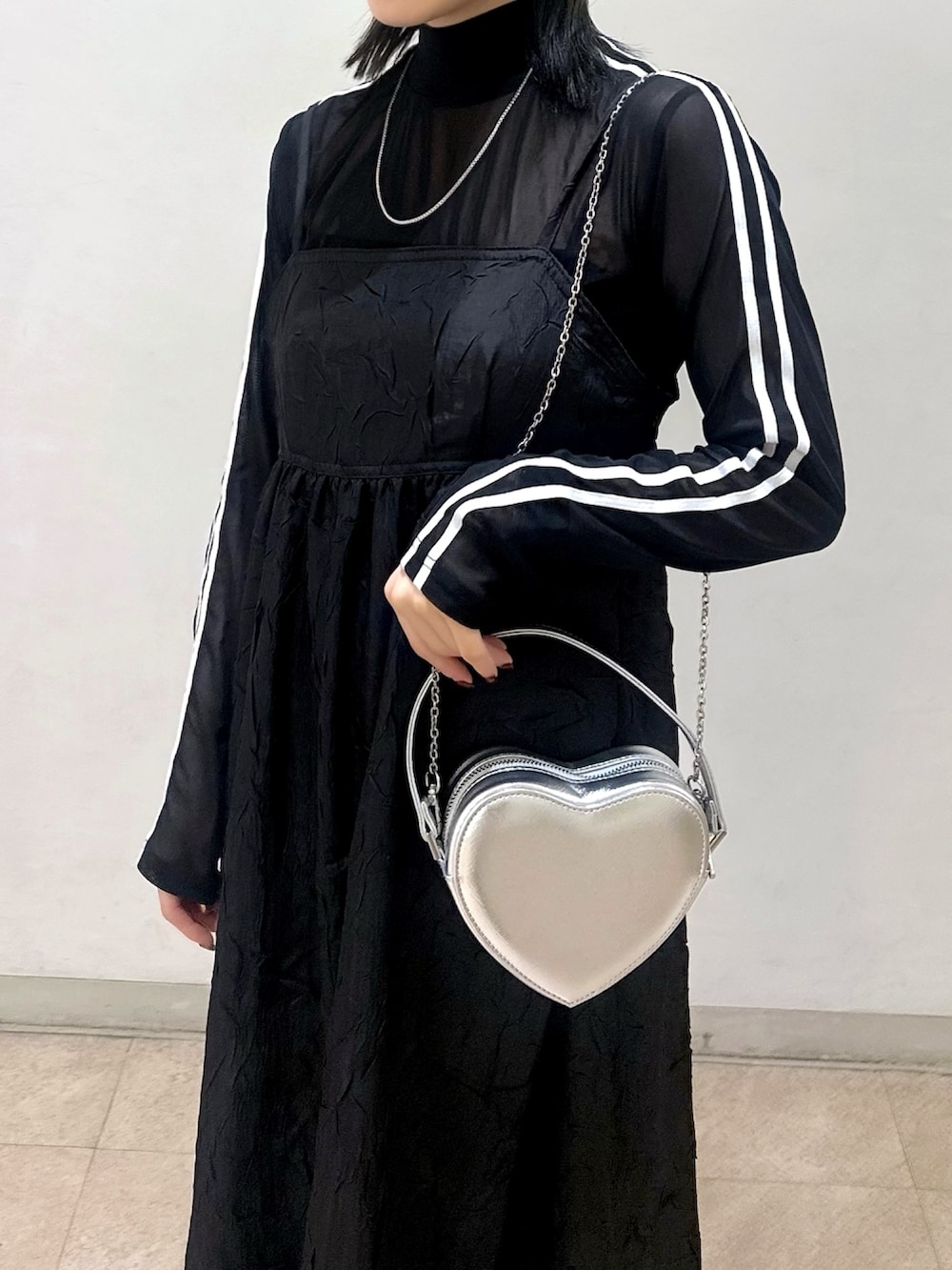 ベージュ系のトレンチコート、ブラック系のワンピース、ブラック系のTシャツ/カットソーを着用したレディースの春コーディネートの5枚目の写真