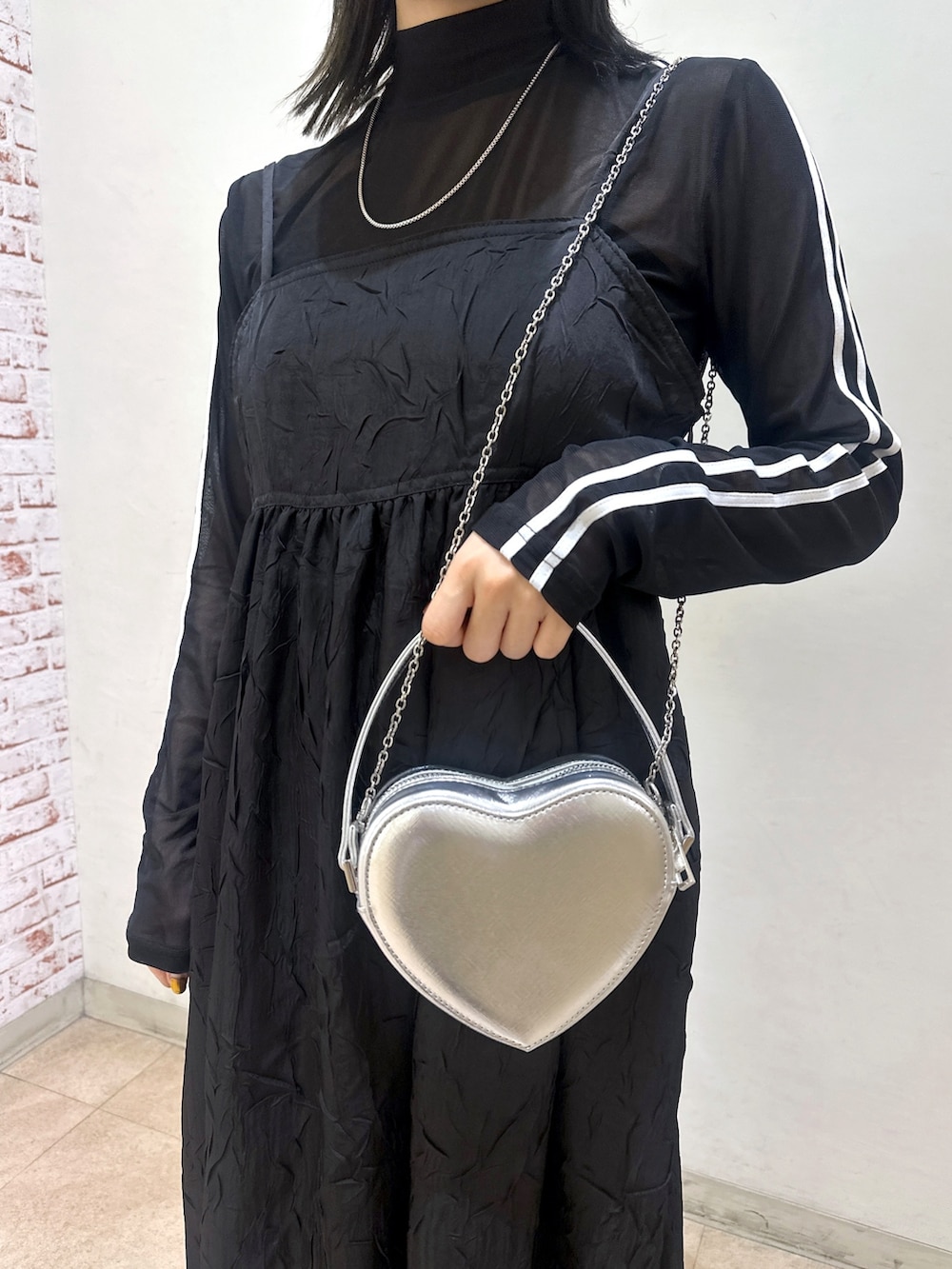 ベージュ系のトレンチコート、ブラック系のワンピース、ブラック系のTシャツ/カットソーを着用したレディースの春コーディネートの7枚目の写真