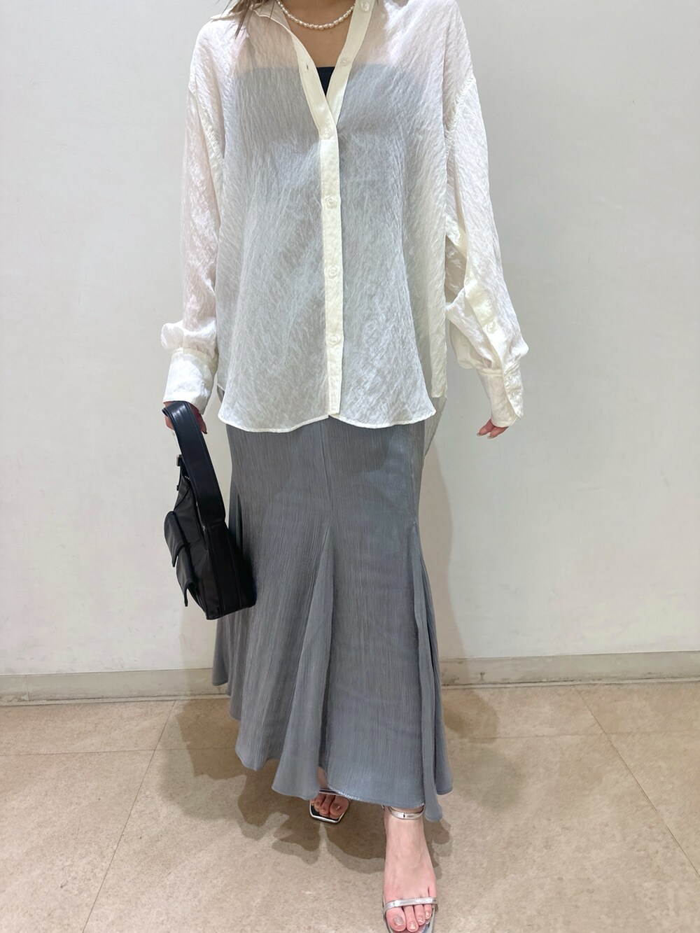 ホワイト系のシャツ/ブラウス、グレー系のスカート、ブラック系のキャミソールを着用したレディースの春コーディネートの3枚目の写真