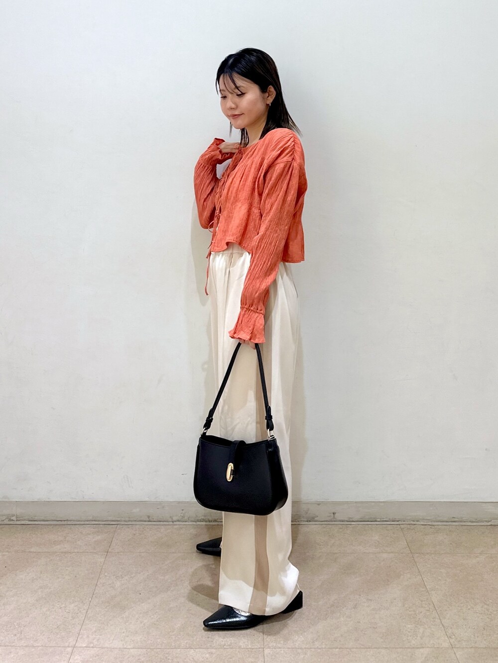 オレンジ系のカーディガン/ボレロ、ホワイト系のキャミソール、ホワイト系のその他パンツを着用したレディースの春コーディネートの2枚目の写真