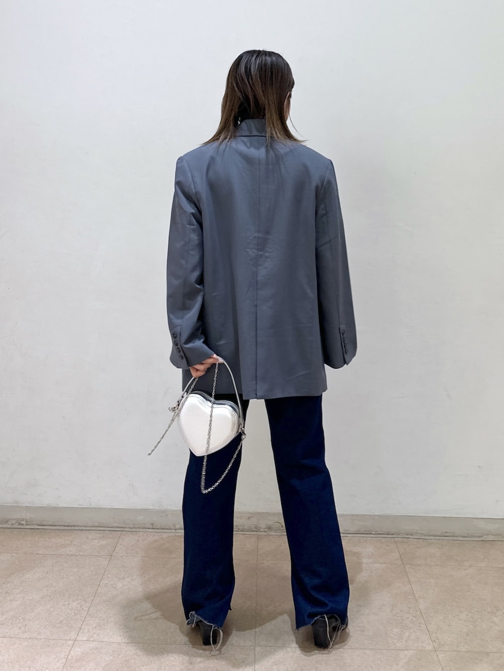 グレー系のテーラードジャケット、ピンク系のニット/セーター、ブラック系のパンプスを着用したレディースの春コーディネートの3枚目の写真