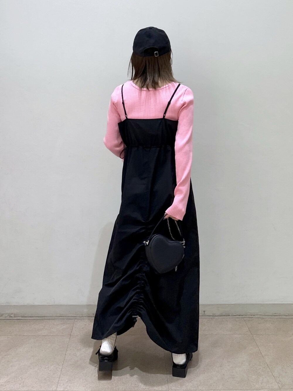 ピンク系のニット/セーター、ブラック系のワンピース、ブラック系のショルダーバッグを着用したレディースの春コーディネートの3枚目の写真