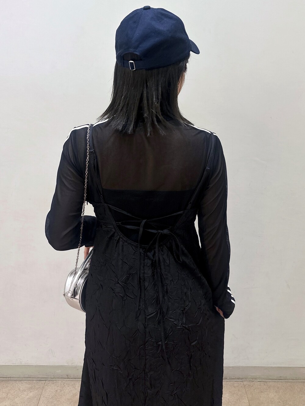 ベージュ系のトレンチコート、ブラック系のワンピース、ブラック系のTシャツ/カットソーを着用したレディースの春コーディネートの6枚目の写真