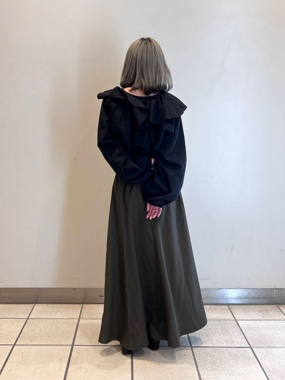 ブラウン系のスカート、ブラック系のシャツ/ブラウスを着用したレディースの春コーディネートの3枚目の写真