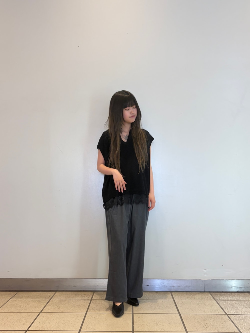 ブラック系のニット/セーター、ブラック系のデニムパンツを着用したレディースの春コーディネートの2枚目の写真
