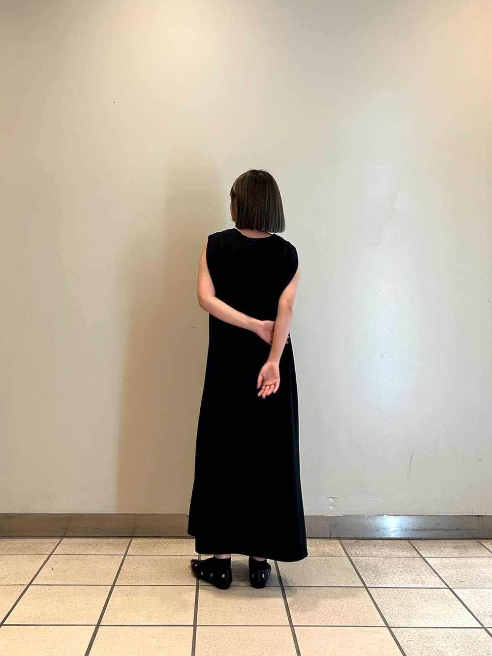 ブラック系のワンピース、ブラック系のパンプスを着用したレディースの秋コーディネートの2枚目の写真