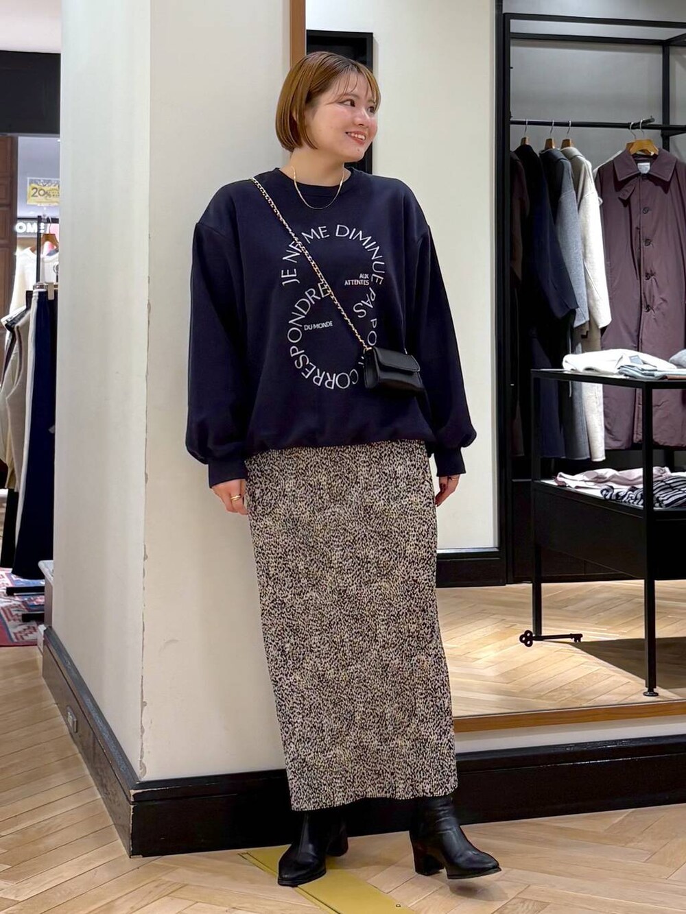 ブラック系のブーツ、ベージュ系のスカート、ブルー系のスウェットを着用したレディースの秋コーディネートの4枚目の写真