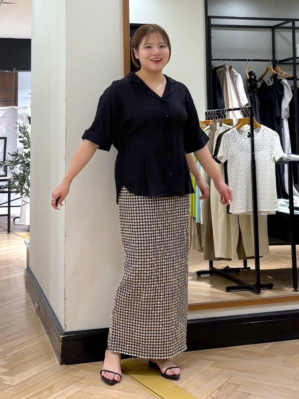 ブラック系のサンダル、ホワイト系のスカート、ブラック系のシャツ/ブラウスを着用したレディースの夏コーディネートの8枚目の写真