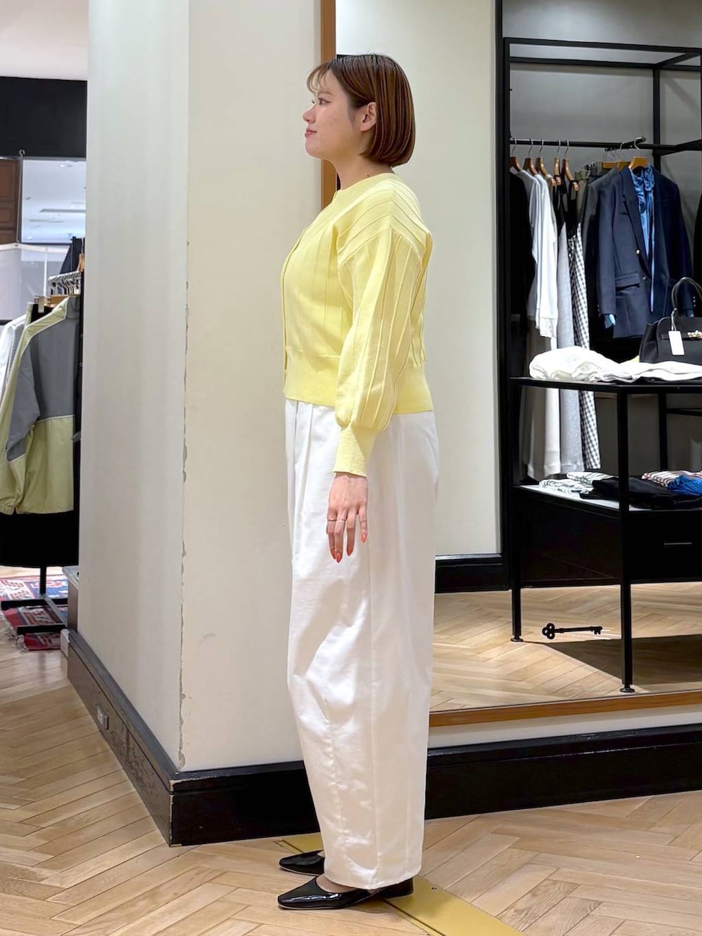 イエロー系のカーディガン/ボレロ、ブラック系のトートバッグ、ブラック系のパンプスを着用したレディースの春コーディネートの6枚目の写真