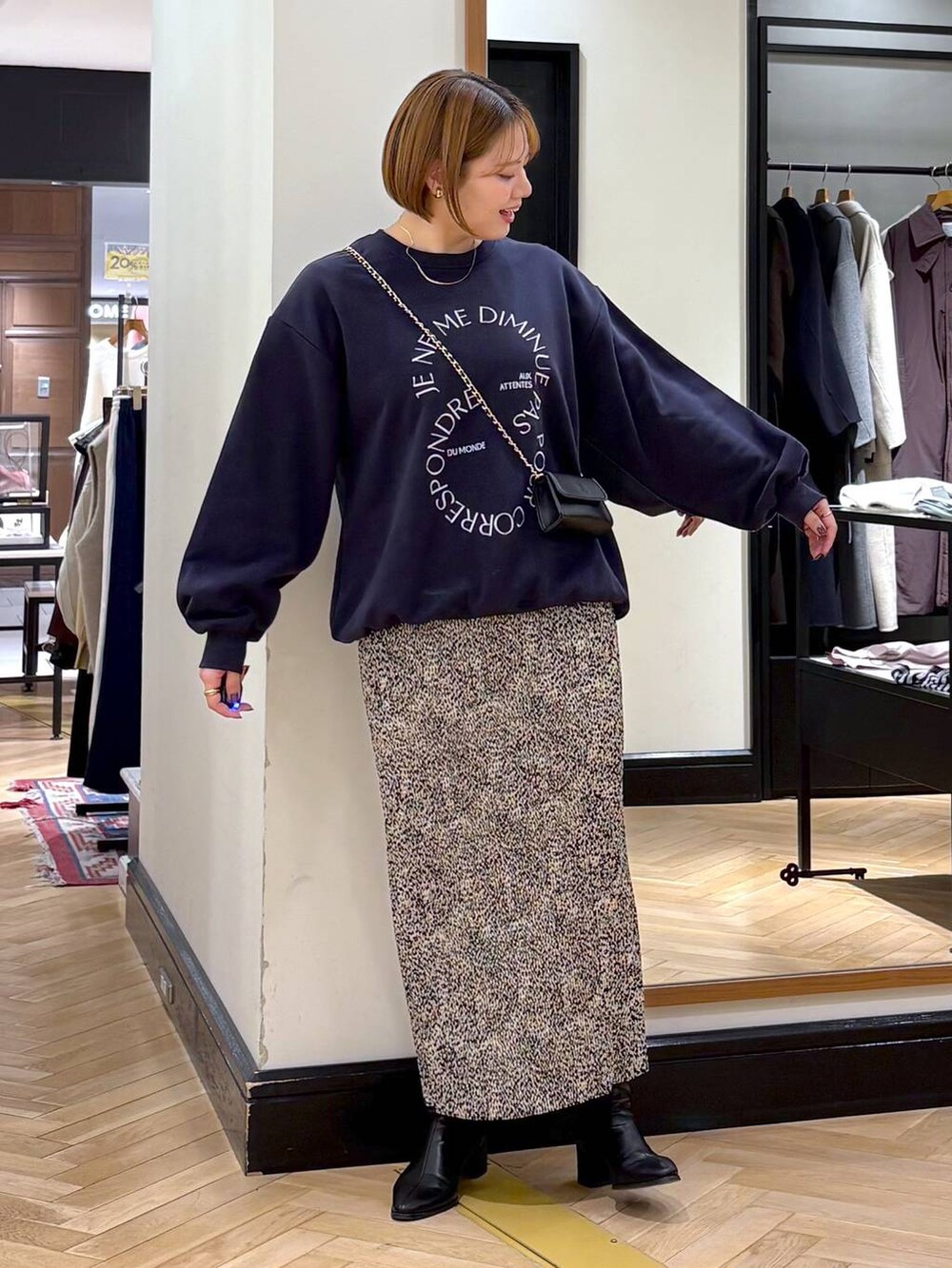 ブラック系のブーツ、ベージュ系のスカート、ブルー系のスウェットを着用したレディースの秋コーディネートの5枚目の写真