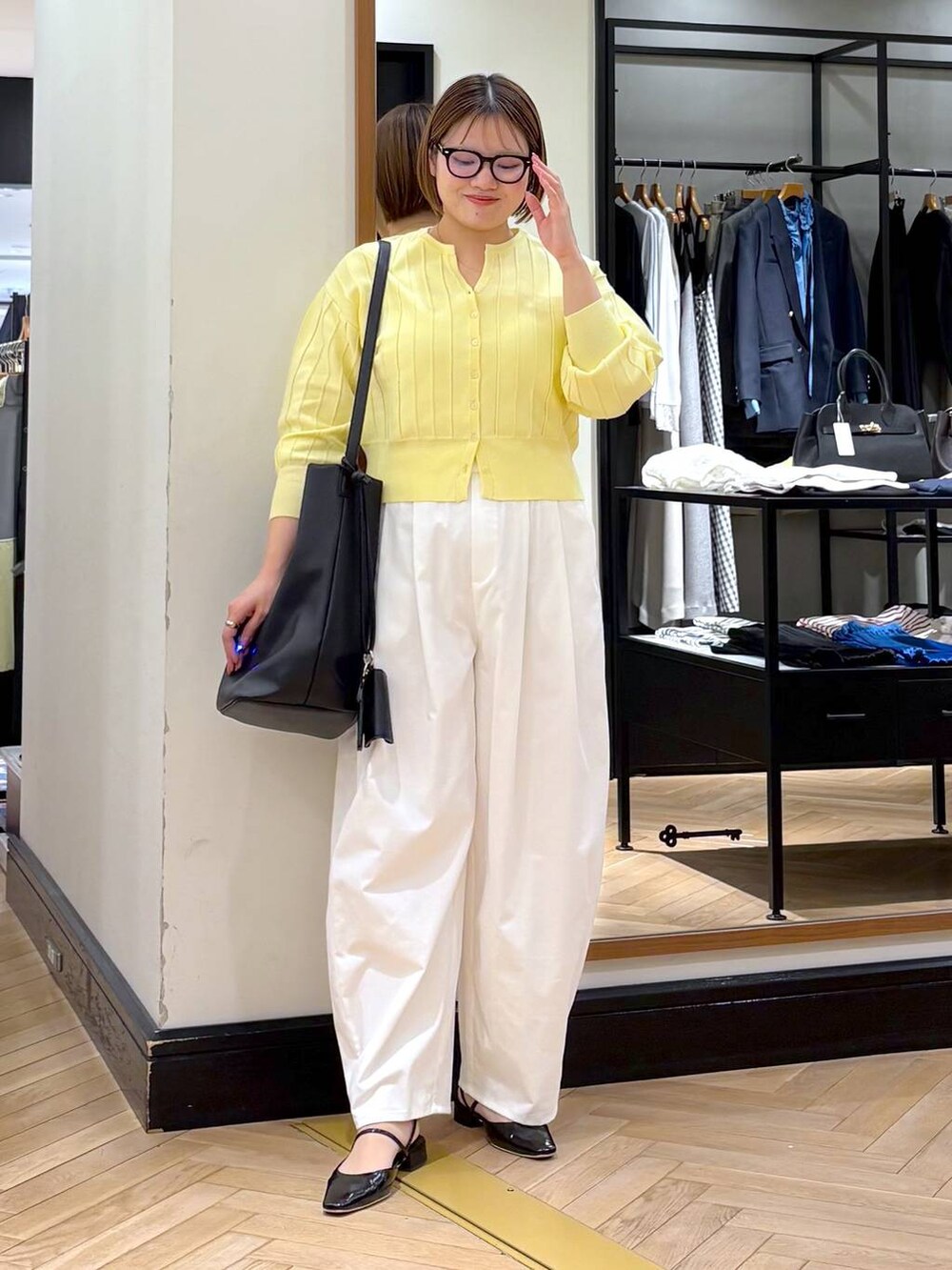 イエロー系のカーディガン/ボレロ、ブラック系のトートバッグ、ブラック系のパンプスを着用したレディースの春コーディネートの4枚目の写真
