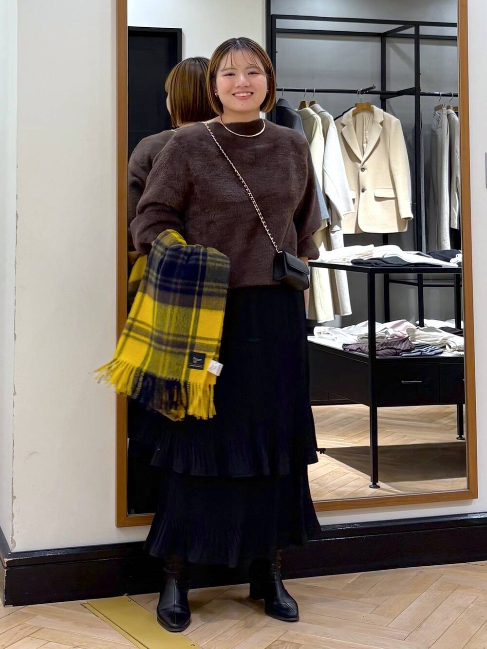 ブラック系のブーツ、ブラック系のスカート、ブラウン系のニット/セーターを着用したレディースの冬コーディネートの3枚目の写真