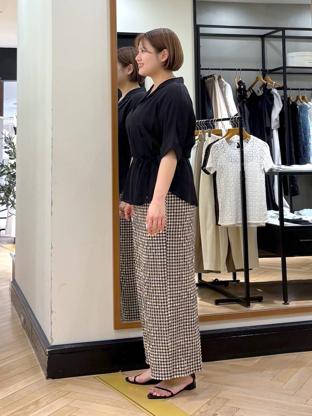 ブラック系のサンダル、ホワイト系のスカート、ブラック系のシャツ/ブラウスを着用したレディースの夏コーディネートの4枚目の写真