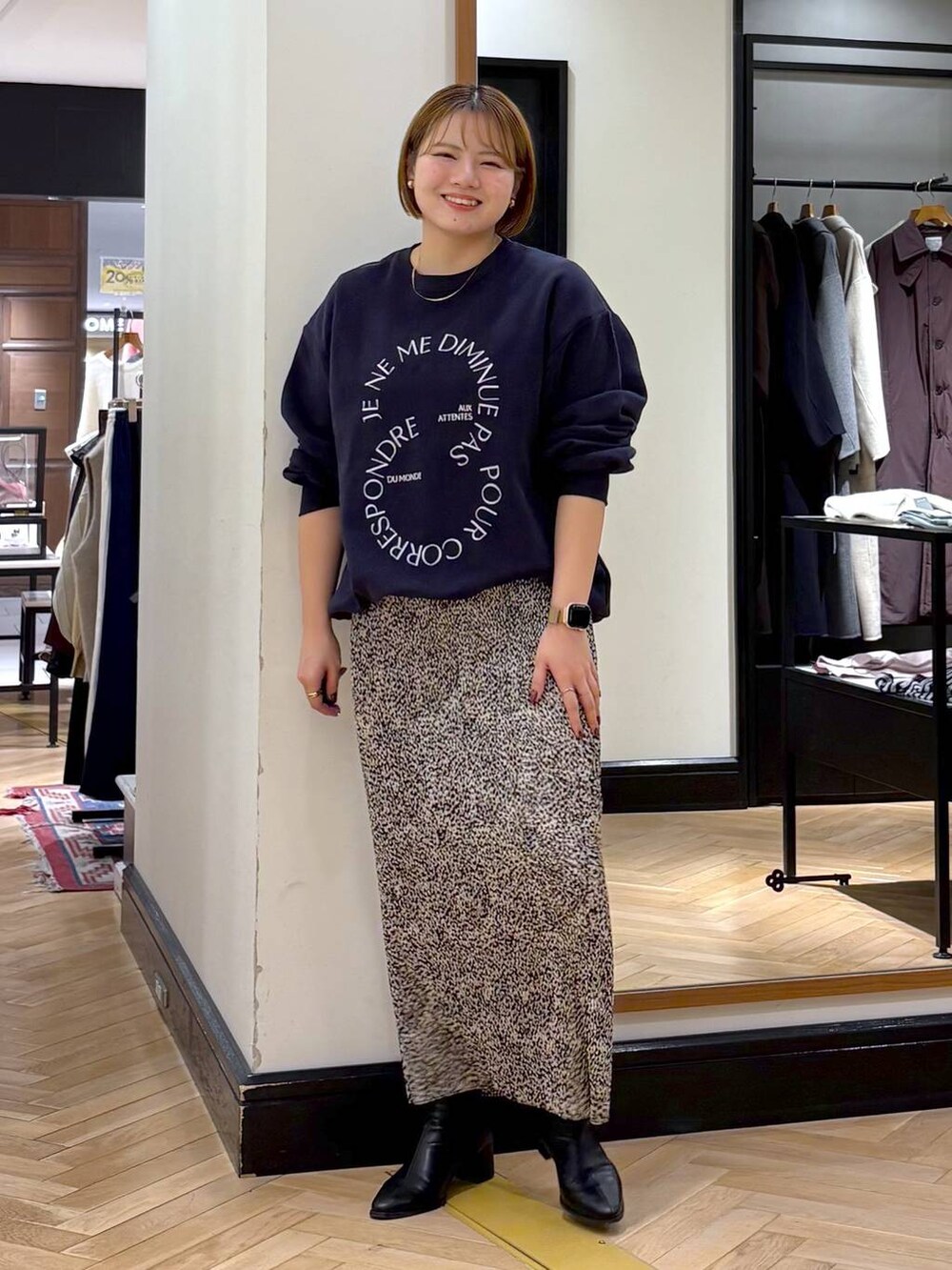 ブラック系のブーツ、ベージュ系のスカート、ブルー系のスウェットを着用したレディースの秋コーディネートの9枚目の写真