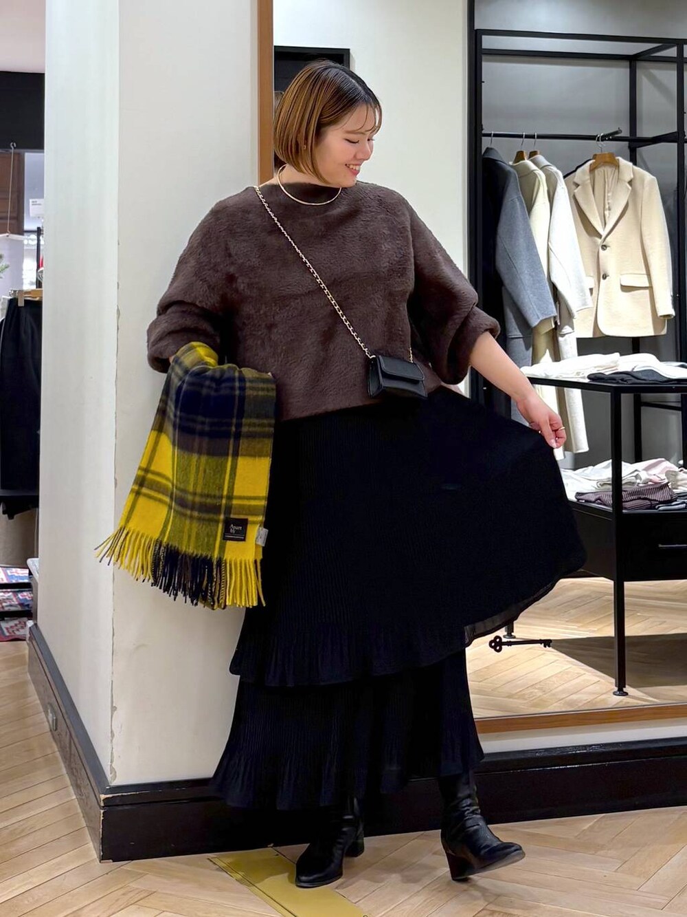 ブラック系のブーツ、ブラック系のスカート、ブラウン系のニット/セーターを着用したレディースの冬コーディネートの4枚目の写真