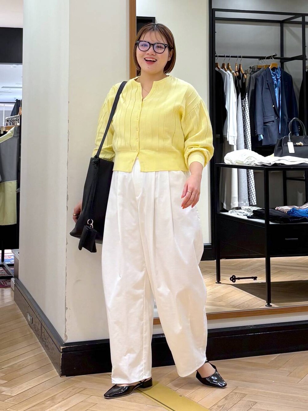 イエロー系のカーディガン/ボレロ、ブラック系のトートバッグ、ブラック系のパンプスを着用したレディースの春コーディネートの3枚目の写真