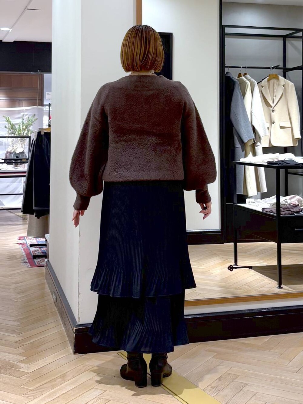 ブラック系のブーツ、ブラック系のスカート、ブラウン系のニット/セーターを着用したレディースの冬コーディネートの7枚目の写真