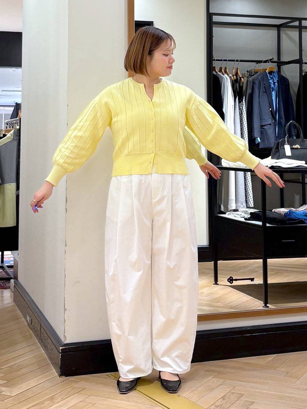 イエロー系のカーディガン/ボレロ、ブラック系のトートバッグ、ブラック系のパンプスを着用したレディースの春コーディネートの5枚目の写真