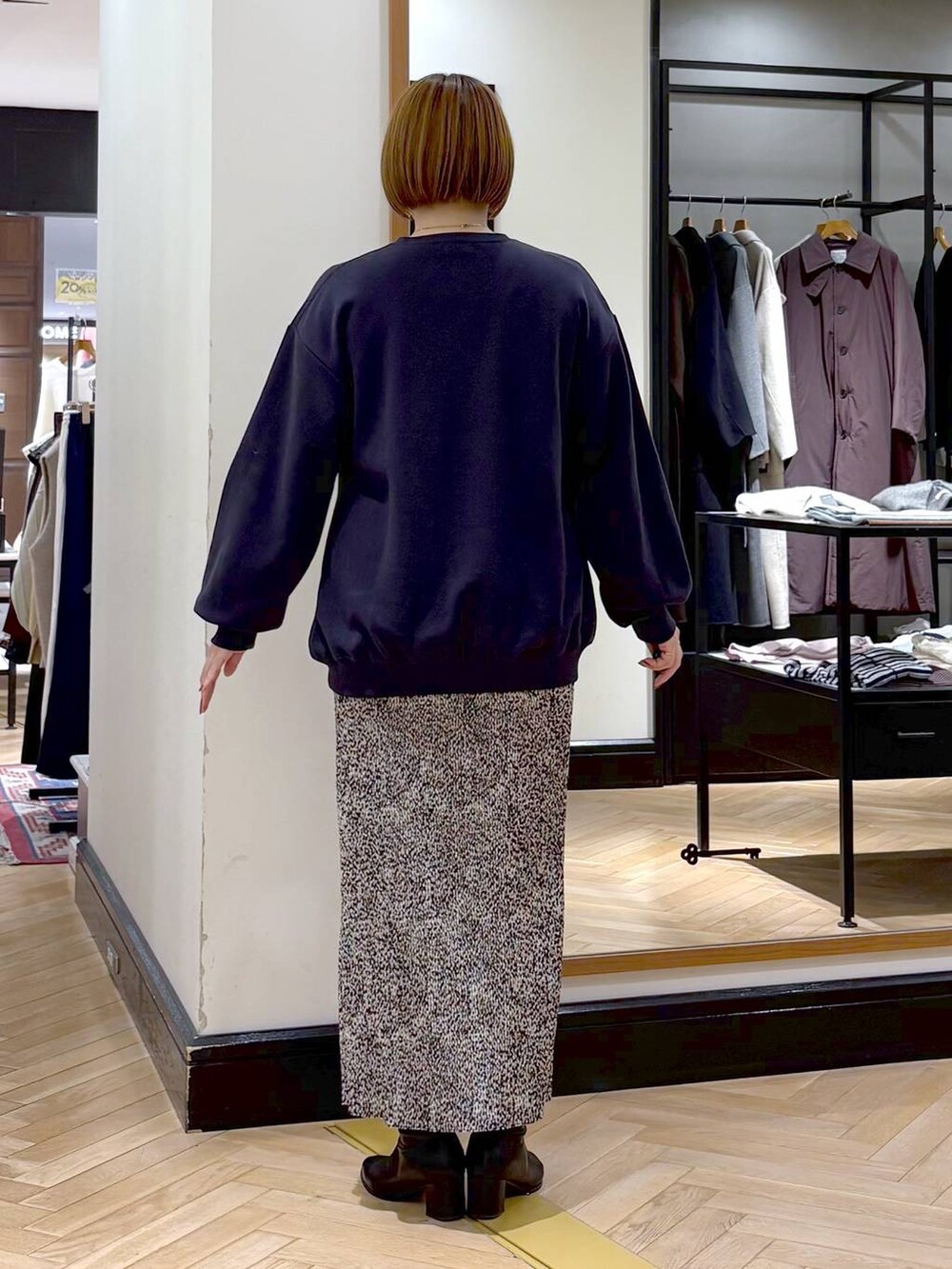 ブラック系のブーツ、ベージュ系のスカート、ブルー系のスウェットを着用したレディースの秋コーディネートの7枚目の写真