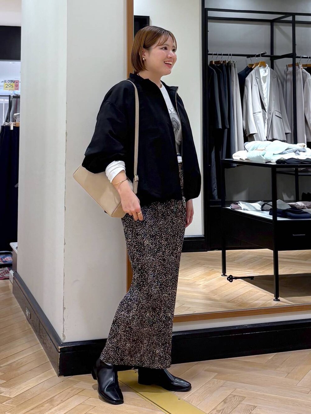 ブラウン系のスカート、ブラック系のブルゾン、ブラック系のブーツを着用したレディースの秋コーディネートの4枚目の写真