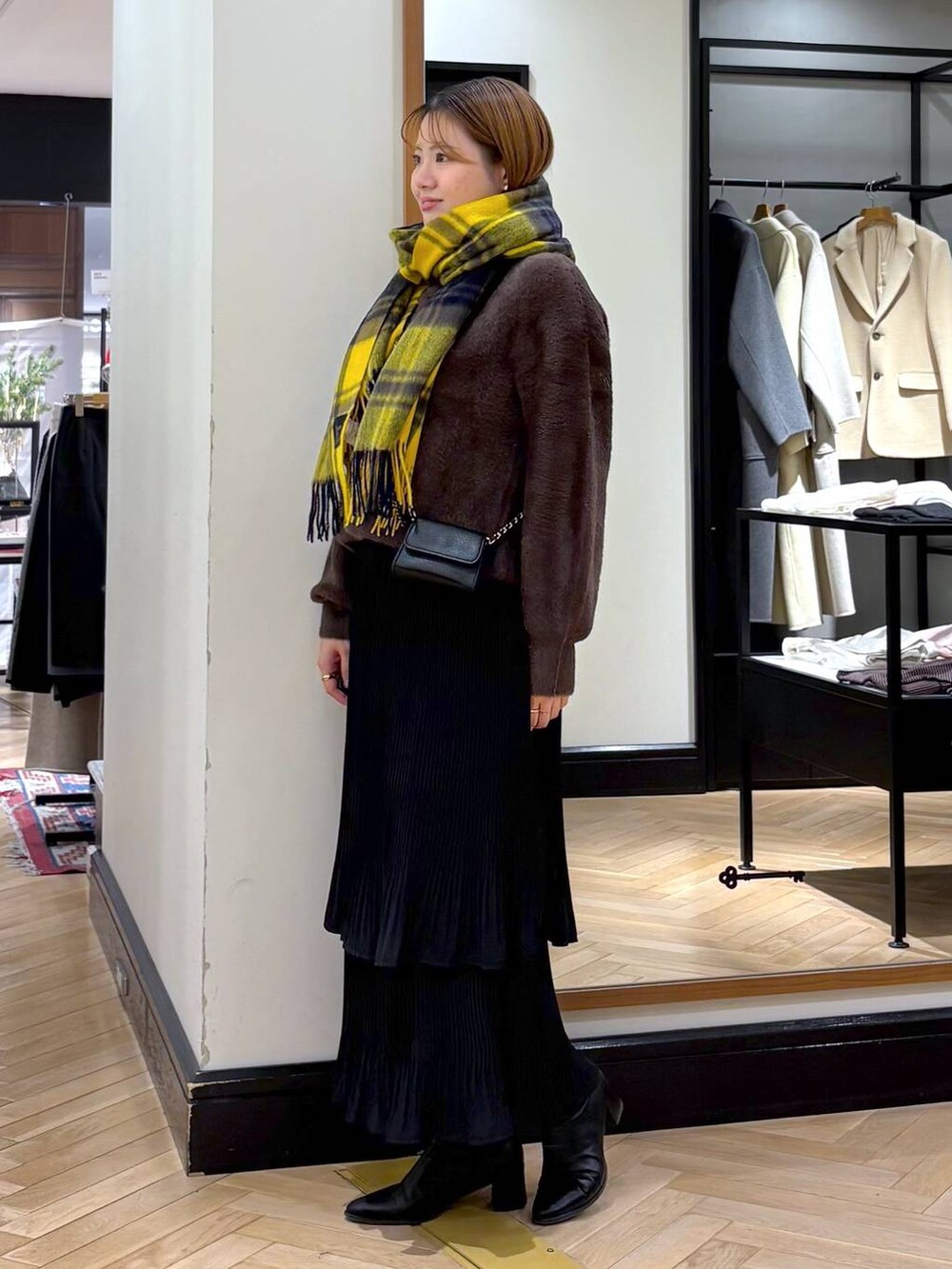 ブラック系のブーツ、ブラック系のスカート、ブラウン系のニット/セーターを着用したレディースの冬コーディネートの5枚目の写真