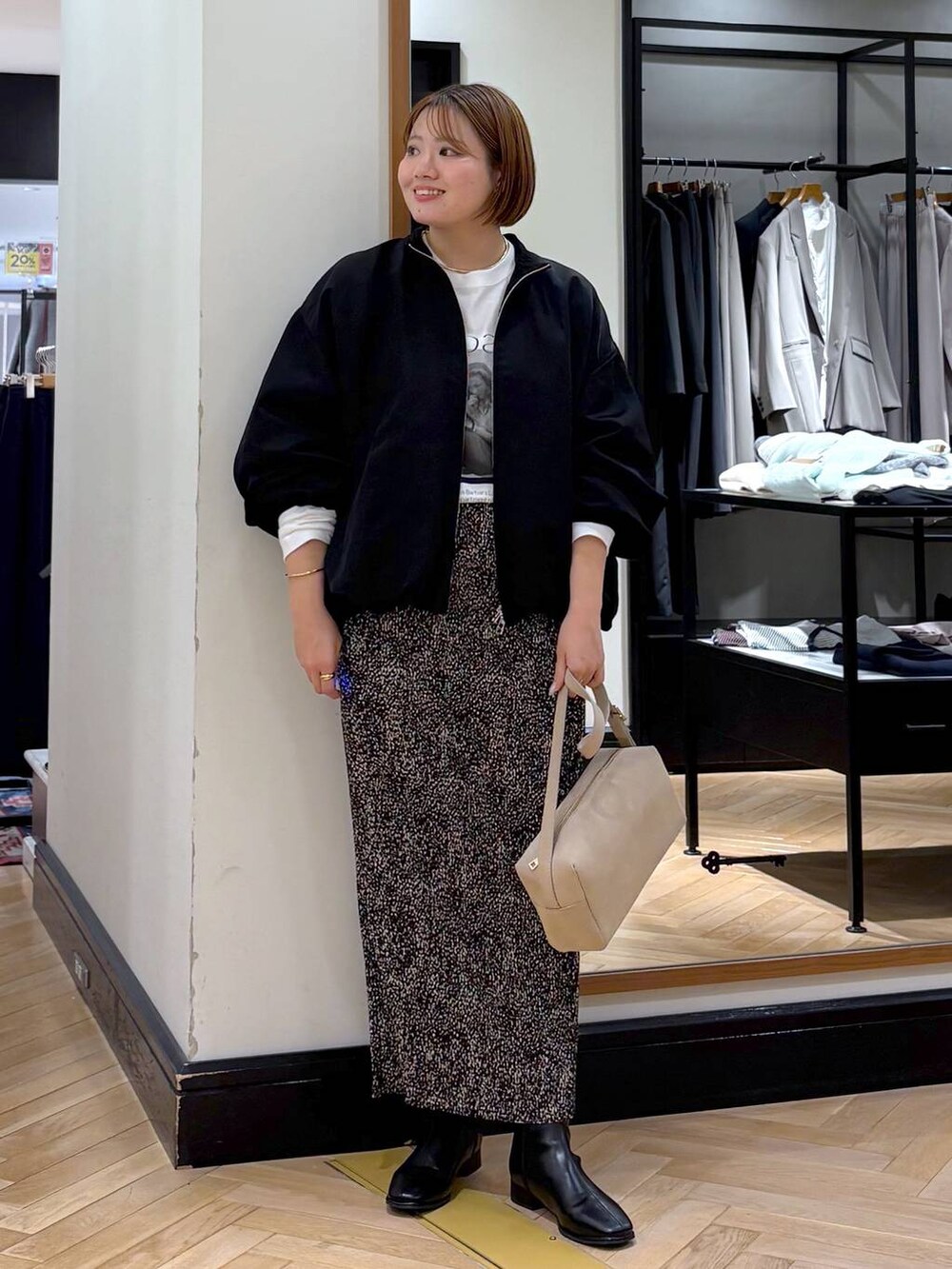 ブラウン系のスカート、ブラック系のブルゾン、ブラック系のブーツを着用したレディースの秋コーディネートの5枚目の写真