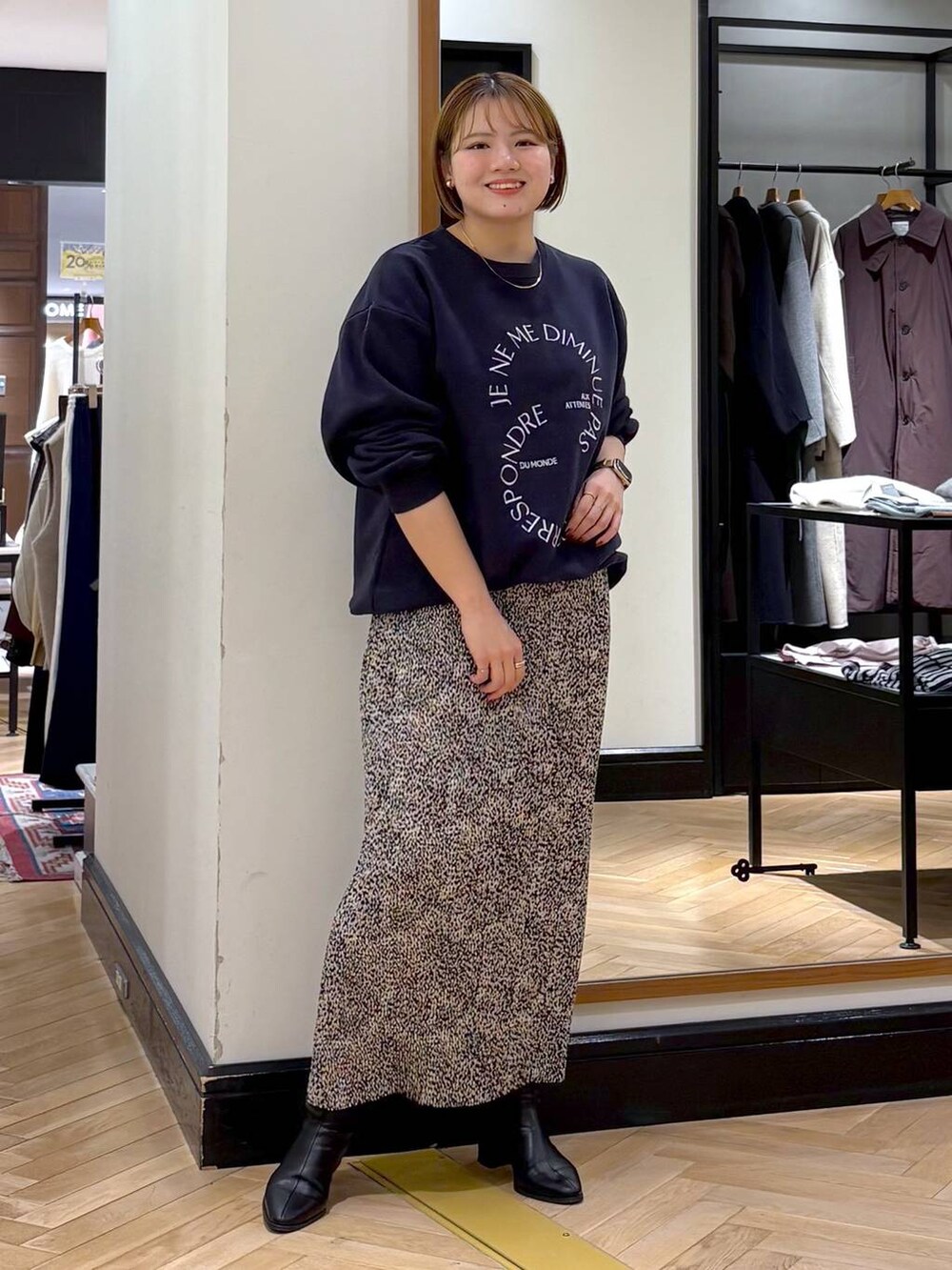 ブラック系のブーツ、ベージュ系のスカート、ブルー系のスウェットを着用したレディースの秋コーディネートの8枚目の写真