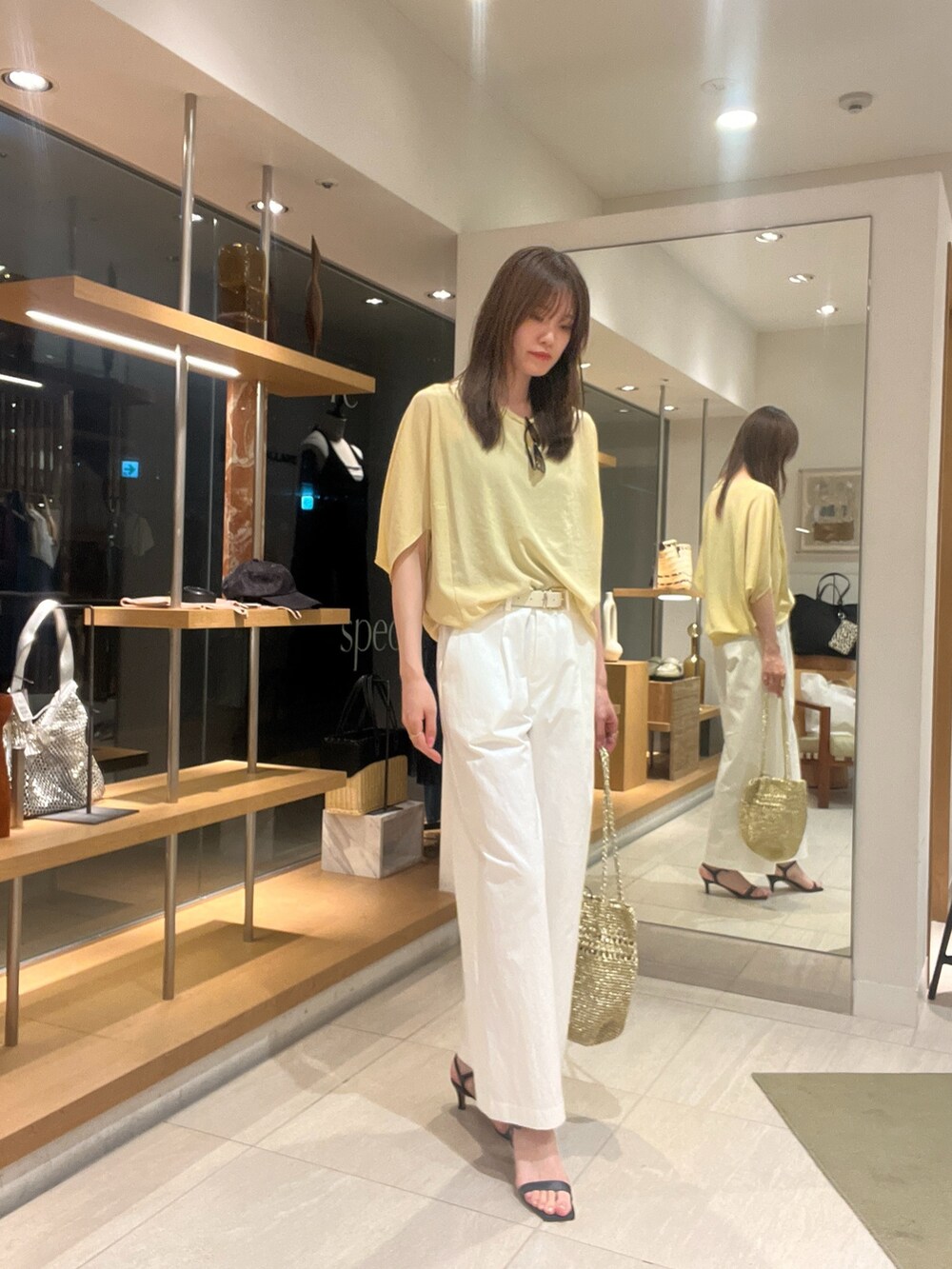 イエロー系のシャツ/ブラウス、ブラック系のサンダル、ゴールド系のトートバッグを着用したレディースの夏コーディネートの4枚目の写真