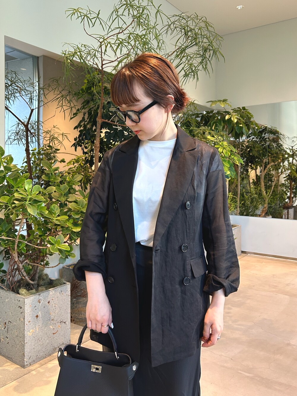 ブラック系のパンプス、ブラック系のテーラードジャケットを着用したレディースの春コーディネートの5枚目の写真