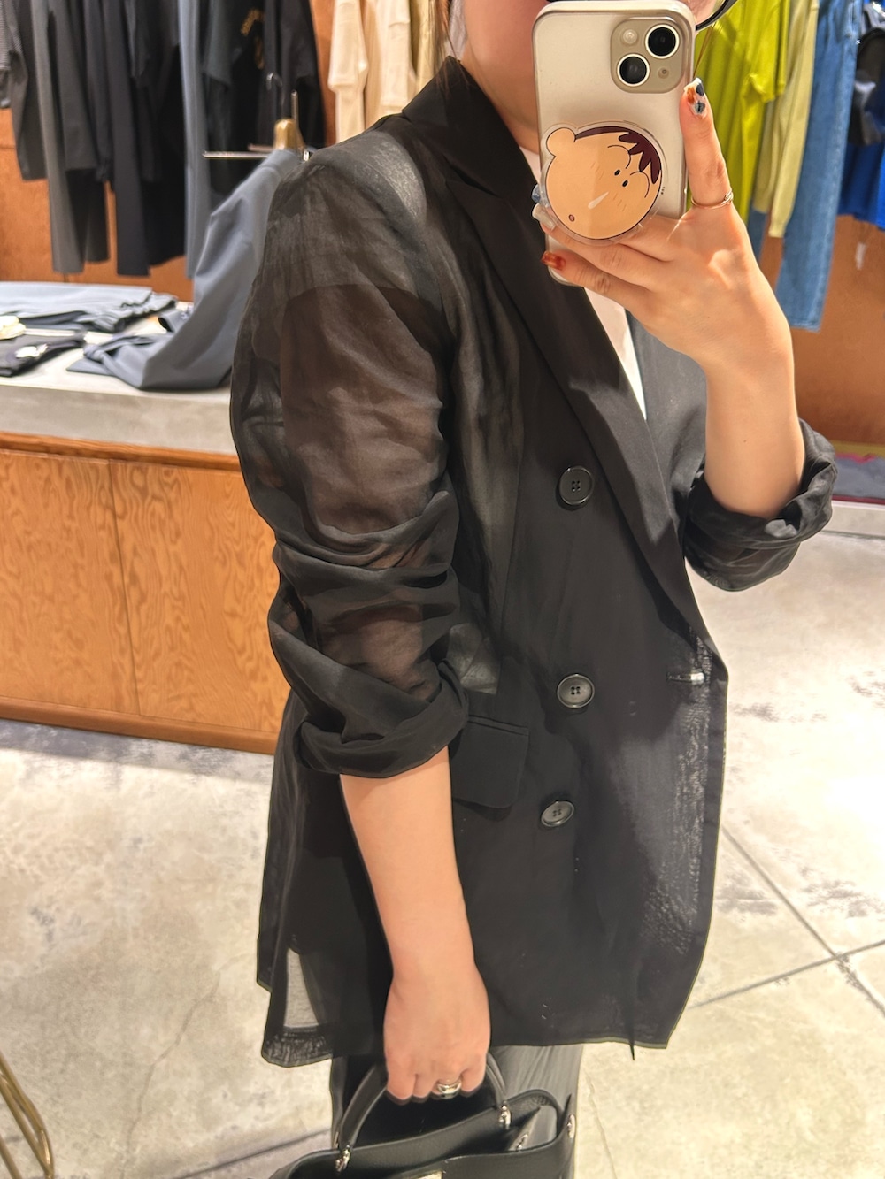 ブラック系のパンプス、ブラック系のテーラードジャケットを着用したレディースの春コーディネートの6枚目の写真