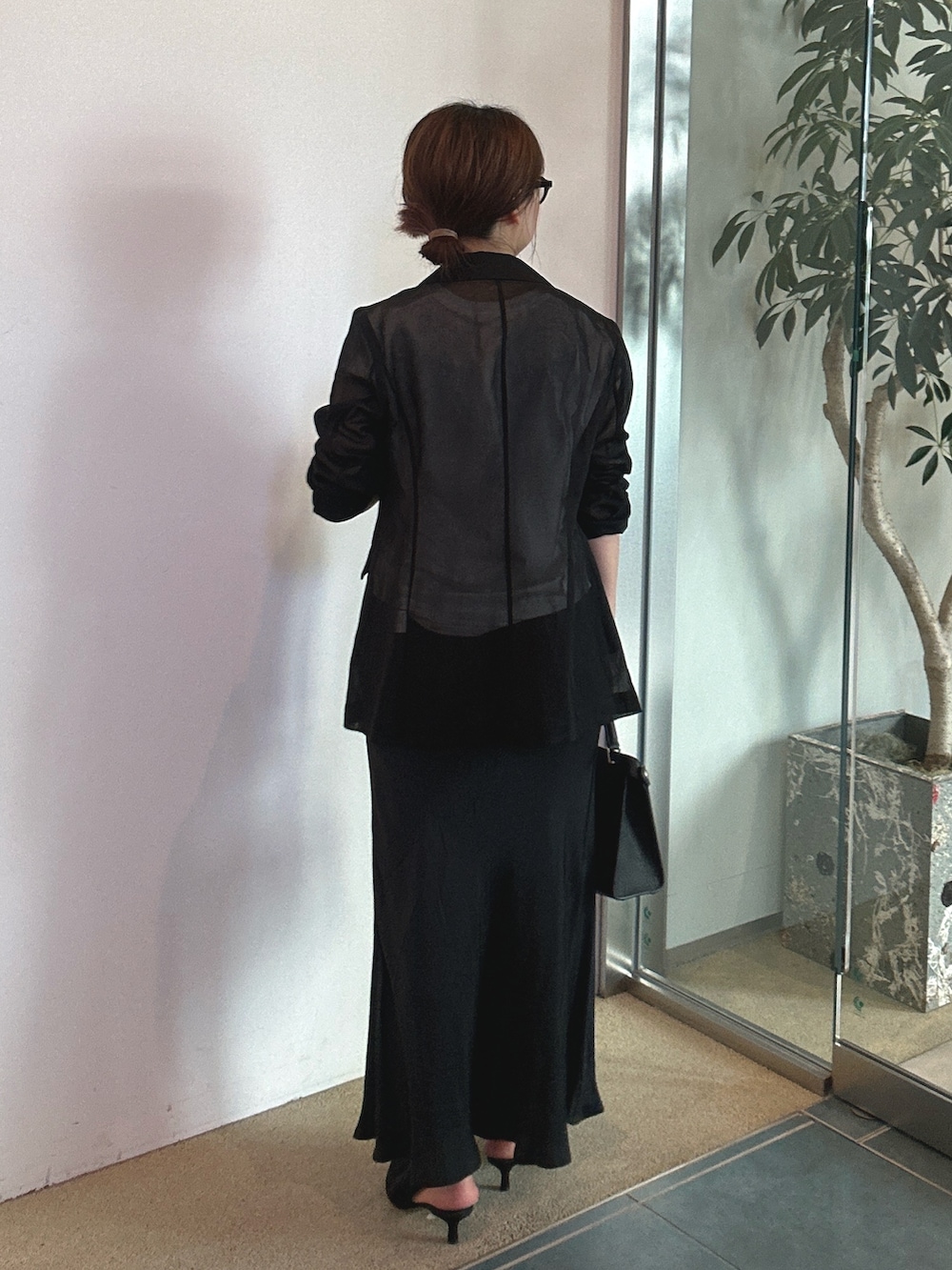 ブラック系のパンプス、ブラック系のテーラードジャケットを着用したレディースの春コーディネートの3枚目の写真